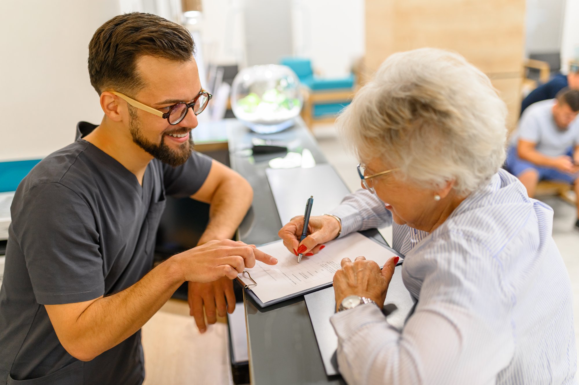 Emiliano Brooklin at the reception desk helping a patient